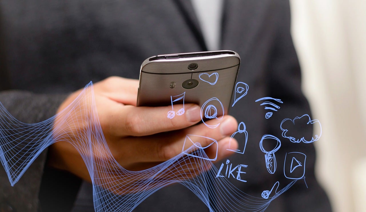 A man in a suit holding a phone with various icons superimposed on it.